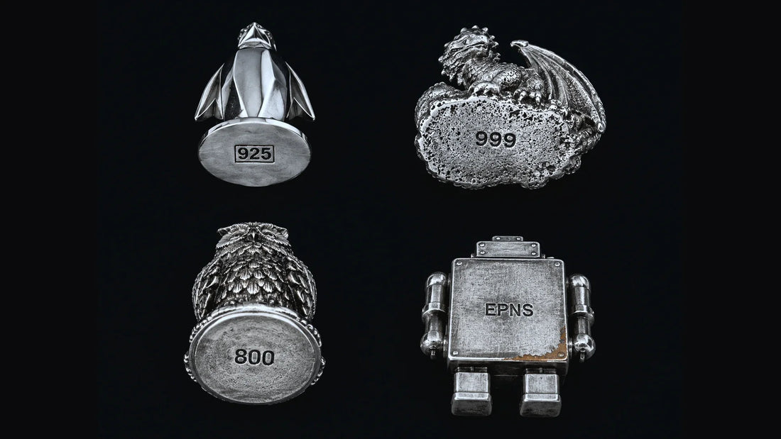 Four silver figurines shown from below with their purity stamps — an Art Deco penguin marked 925, a hand-poured dragon marked 999, a Victorian owl marked 800, and a toy robot marked EPNS with copper showing through worn plating